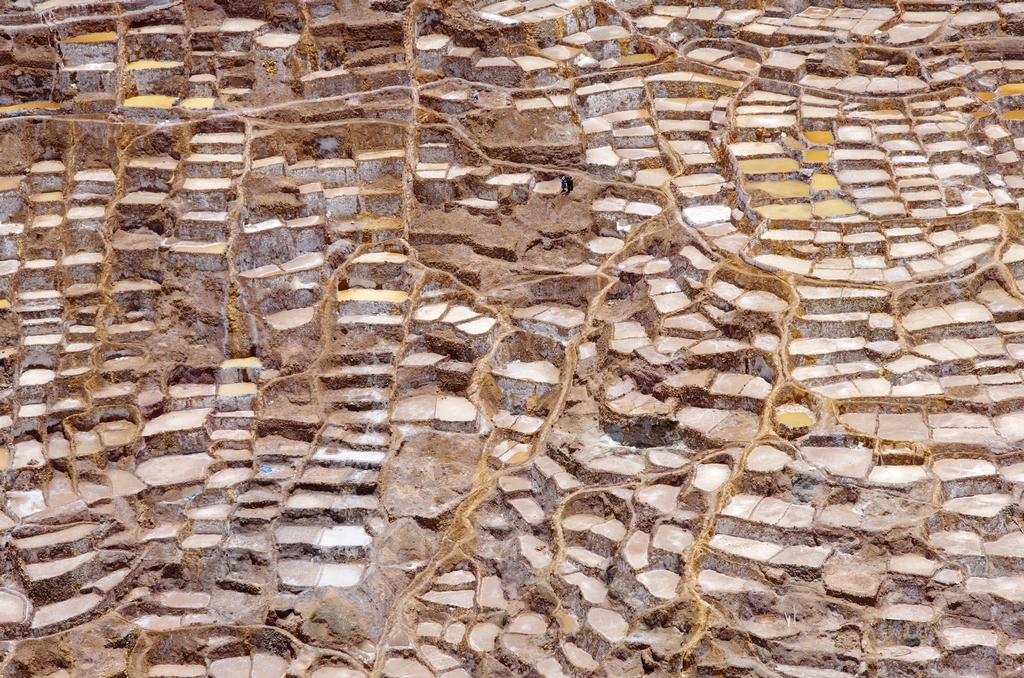 Salines de Maras. L'échelle est donnée par la présence des 3 personnes sur l'image - Pérou